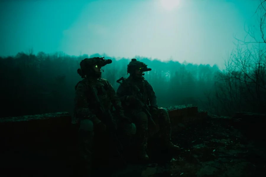 Soldier at night with a night vision device looking at the sky